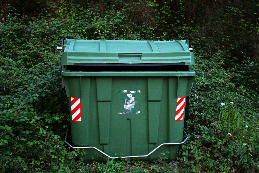 Contenedor de basura de polietileno en medio de la vegetación